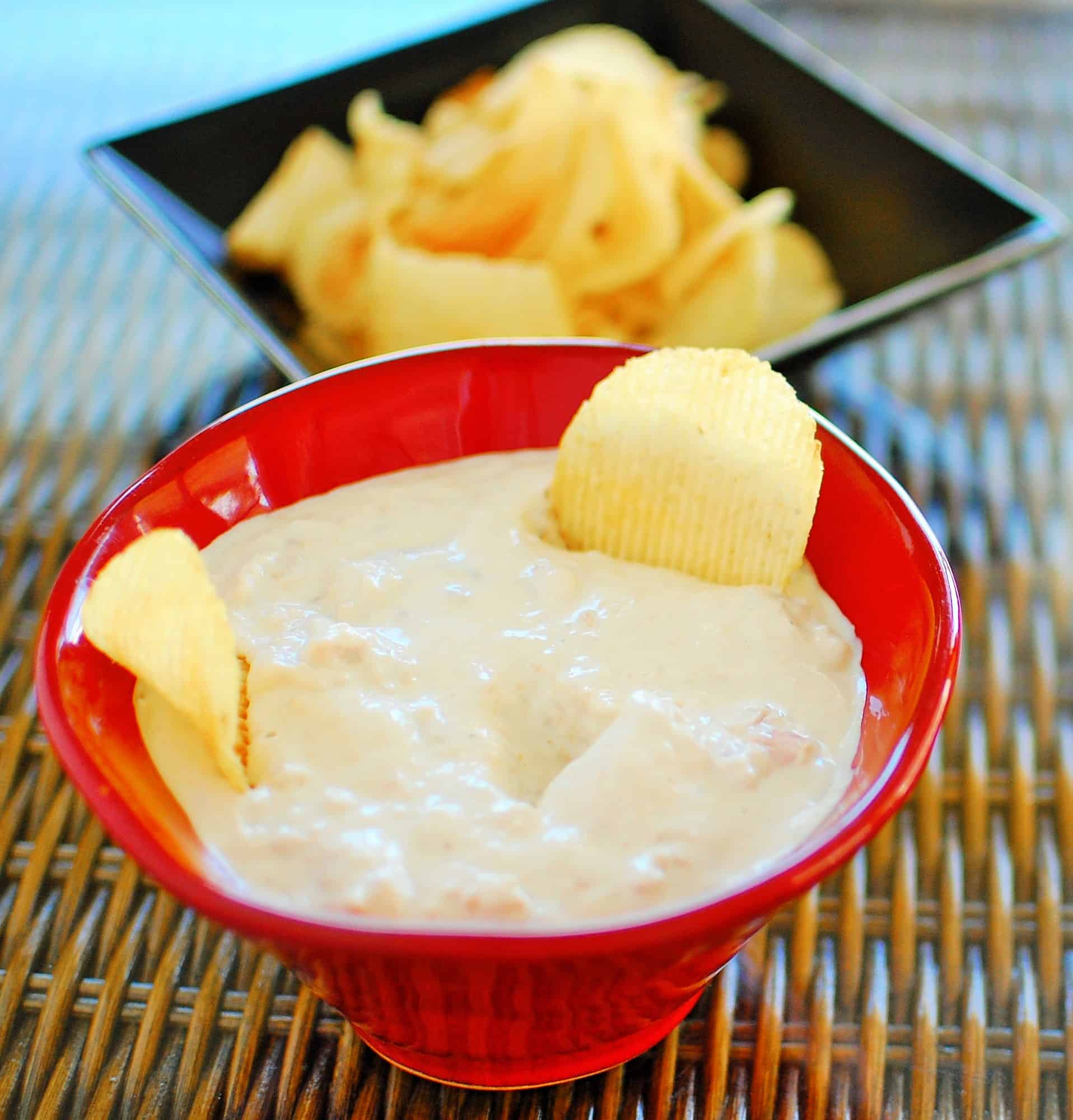 Clam Dip in a bright red bowl.