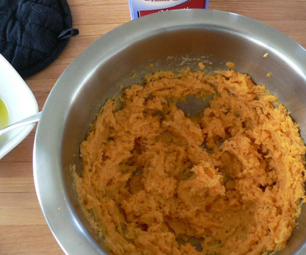 Mashed sweet potatoes in a stainless bowl.