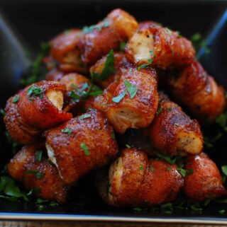 Bacon Wrapped Chicken bites in a black bowl.