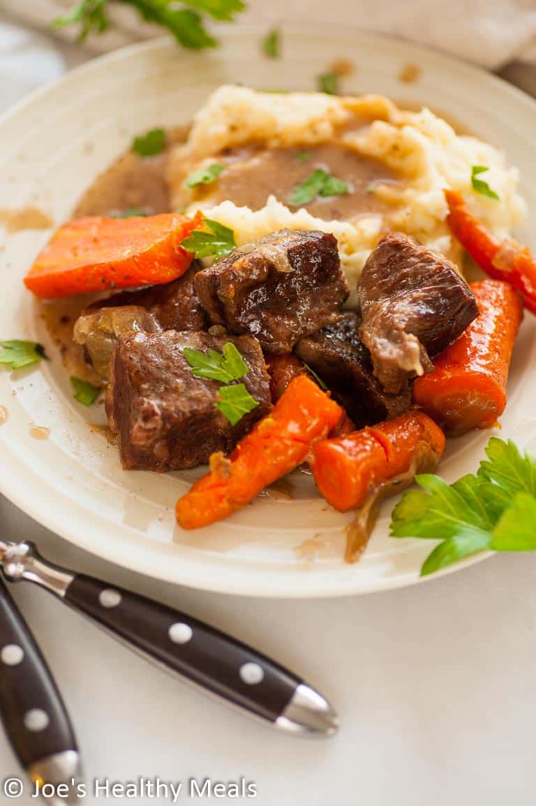 Short ribs, carrots and potatoes on a plate.