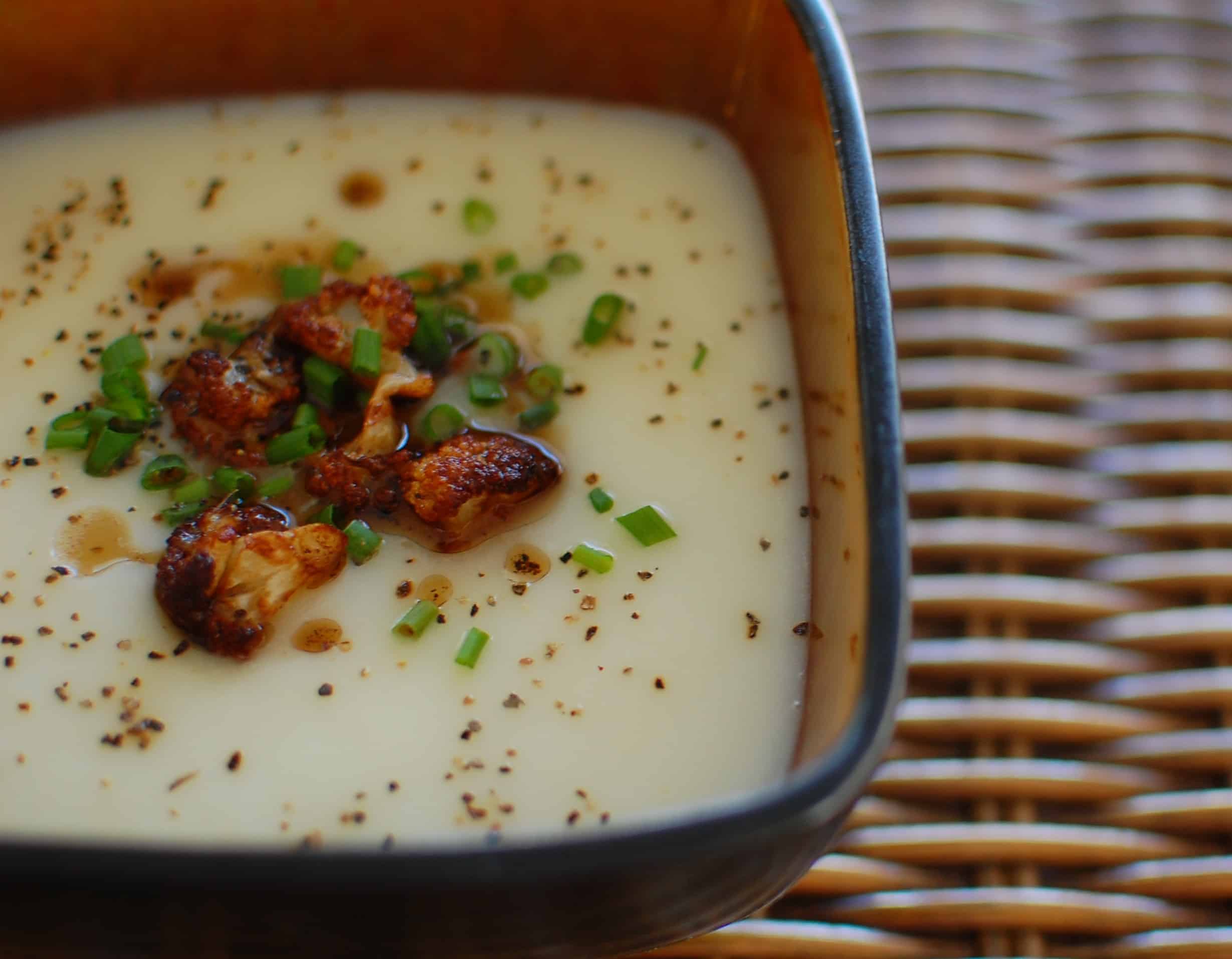 Close-up of a bowl if cauliflower soup with browned florets.