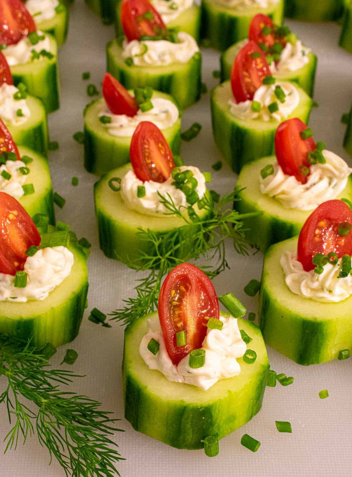 Cucumber slice with cream cheese and grape tomato slice.