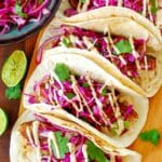 Overhead view of fish tacos with red cabbage.