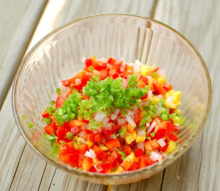 Mixing the chopped fruit and vegetables in a bowl.