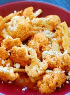 Roasted Cauliflower in Buffalo Sauce - sprinkled with crumbled blue cheese. What a delicious treat! | joeshealthymeals.com