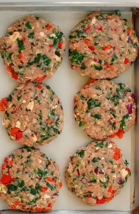 Greek style turkey burger patties on a small sheet pan.
