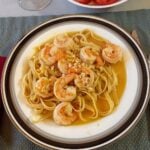 Plate of shrimp on fettuccini with wine sauce.