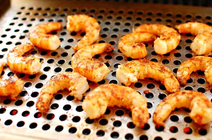 Seasoned shrimp on a gas grill.