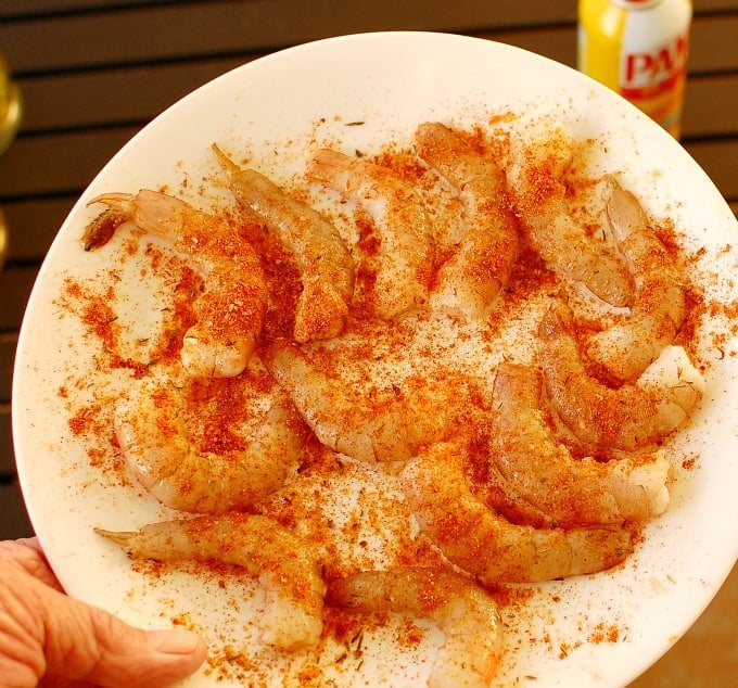 Plate of seasoned shrimp ready to be placed on the grill.