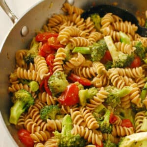 Overhead view of pasta and vegetables in a skillet.