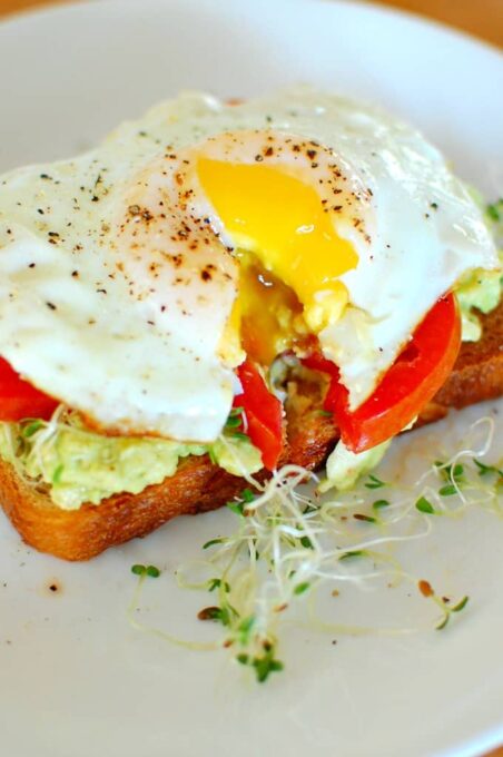 Avocado toast with egg and sprouts. Great for breakfast or brunch. | joeshealthymeals.com