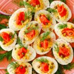 Deviled eggs on a platter with fresh dill weed.
