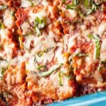 Casserole dish with cooked Italian sausage lasagna rollups.