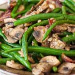 Green beans bacon and mushrooms on a plate.