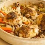 Chicken thighs and vegetables in a ceramic dish.