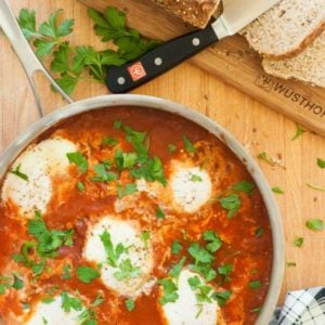 Finished shakshuka with poached eggs in a skillet.