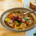 Bowl of leftover turkey soup with bacon crumbles on top.