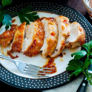 Plate full of sliced chicken with chili sauce.