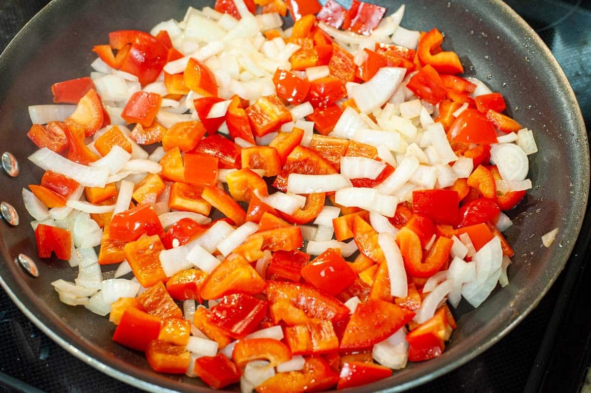 Skillet with onions and red peppers.