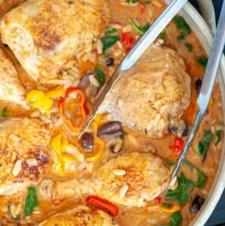 Overhead view of chicken with tongs.