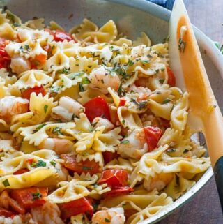 Pasta with Roma tomatoes and shrimp sauce in a skillet.