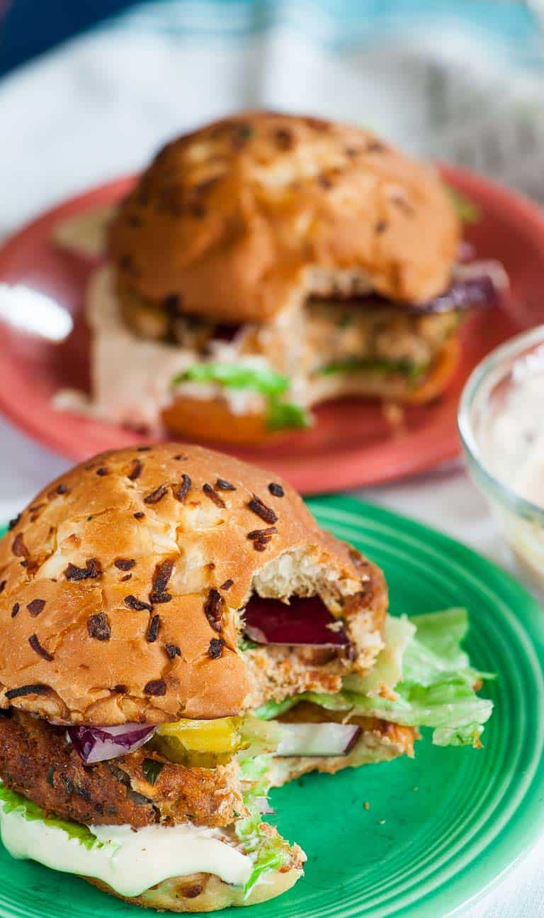 Toasted bun with salmon with a bite out of it.