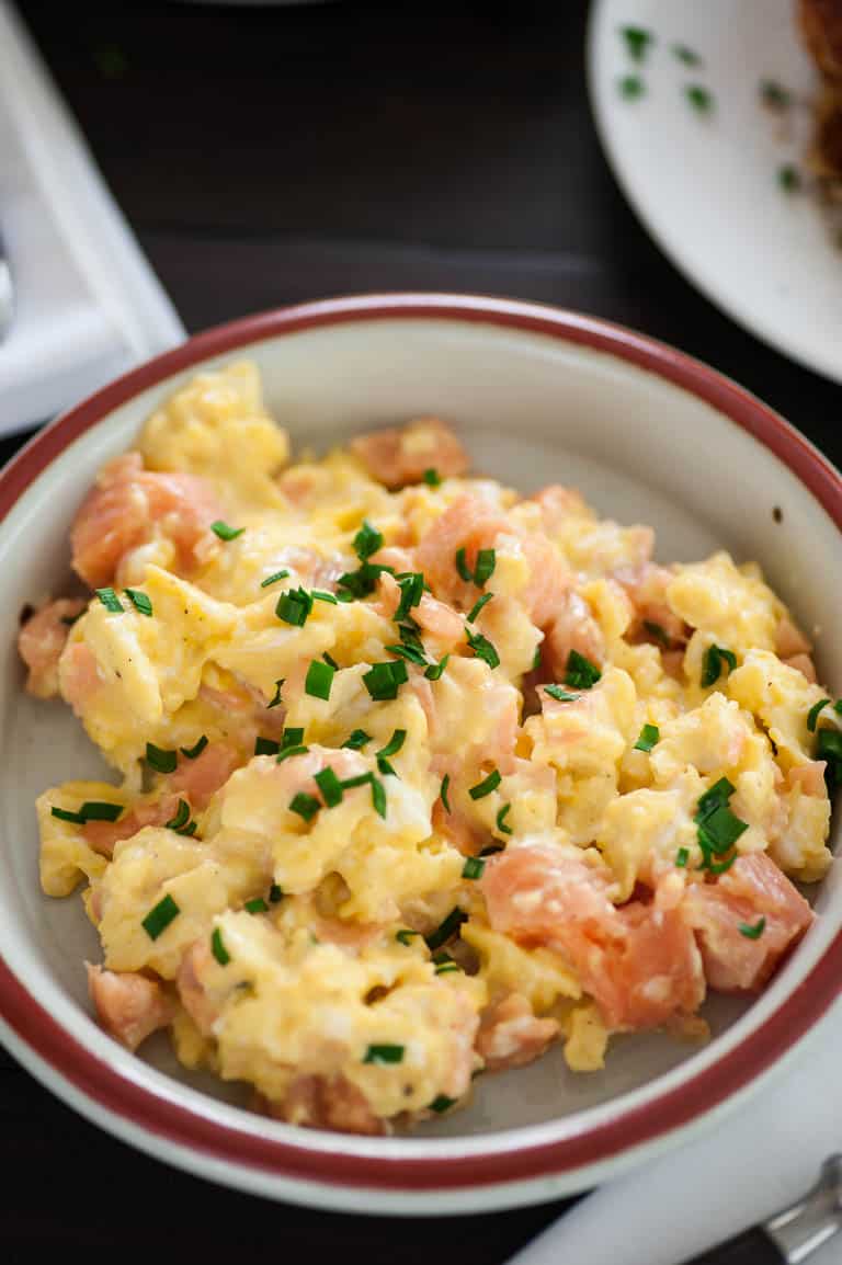 Creamy scrambled eggs with smoked salmon in a bowl.