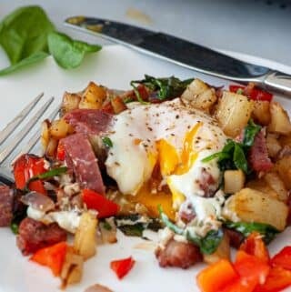 Plate of breakfast hash and fried egg.