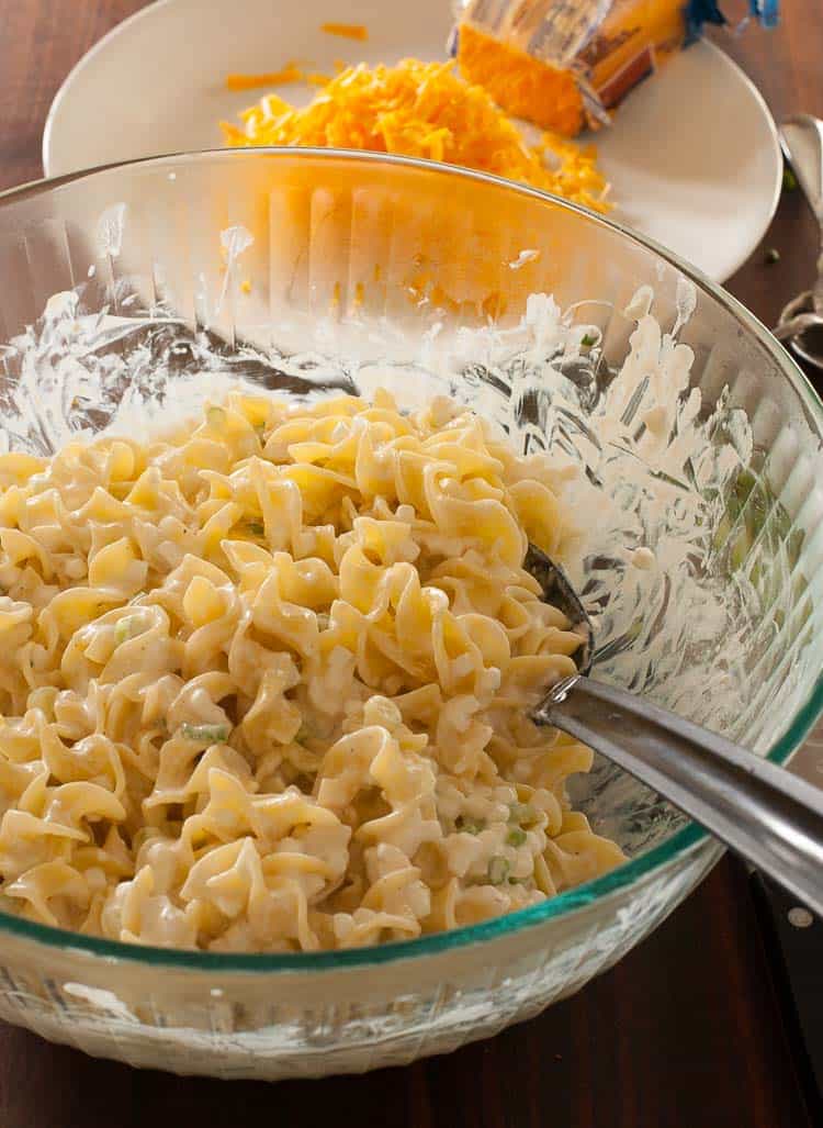 Ingredients being mixed in a bowl for the cheesy beef noodle bake.