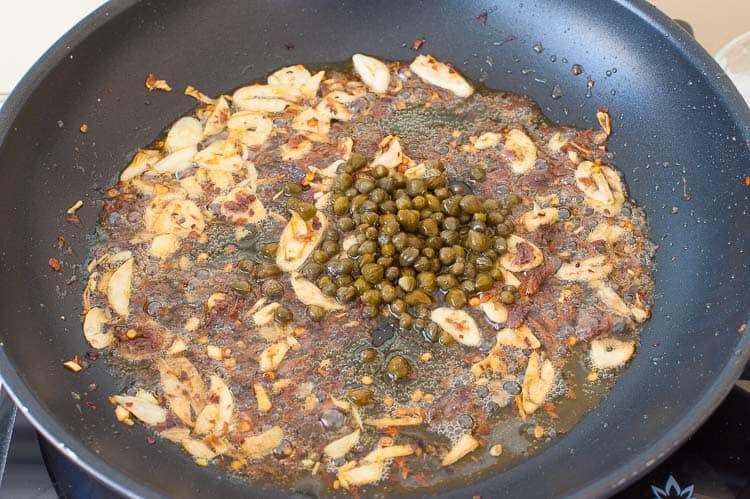 Add the capers to the same skillet with the garlic and anchovy.