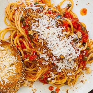 Plate of spaghetti with bread crumbs and cheese.