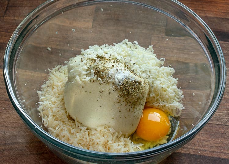 Cheese and raw egg in a bowl.