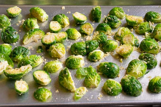 Brussels sprouts on a sheet pan ready for the oven. 