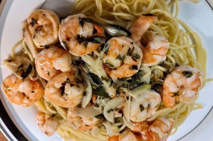 Shrimp scampi on top of spaghetti.