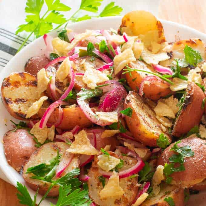 Grilled baby red potatoes with pickled red onions in a bowl ready to serve. 