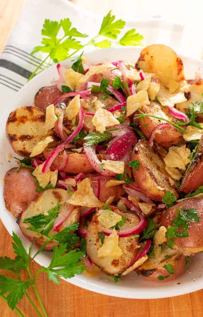 Grilled baby red potatoes with pickled red onions in a bowl ready to serve. 