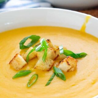 Beer cheese soup with croutons and green onion.