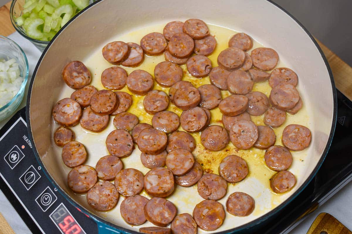 Andouille sausage for jambalaya being browned on a Dutch oven.