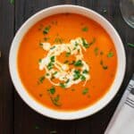 Tomato bisque in a bowl with parsley garnish.