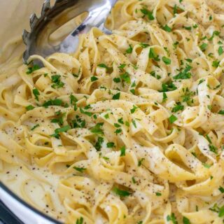 homemade fettuccine with Alfredo sauce in a skillet