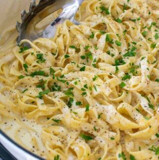 homemade fettuccine with Alfredo sauce in a skillet