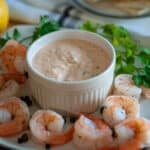 Bowl of seafood sauce with poached shrimp.