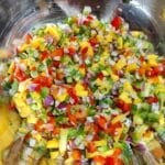 A bowl of mango salsa that is ready to eat.