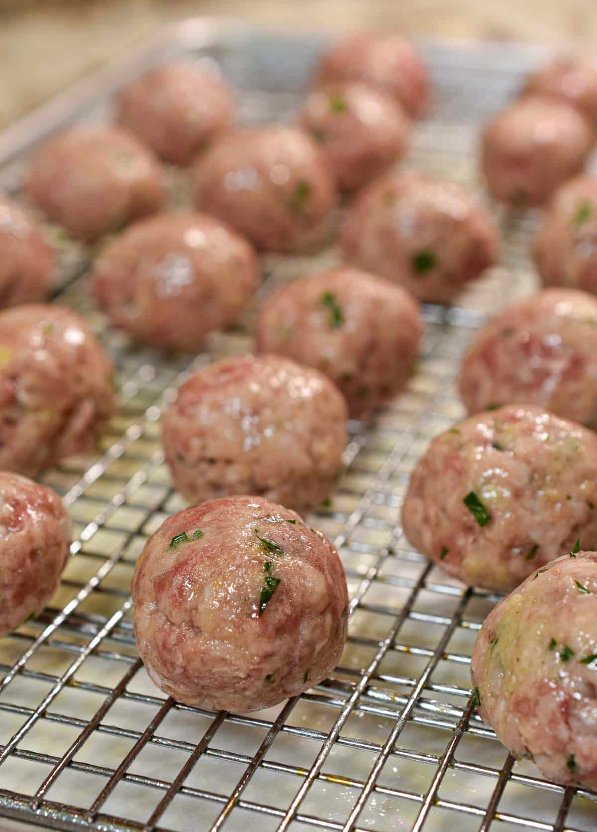 Meatballs on a baking rack ready to bake.