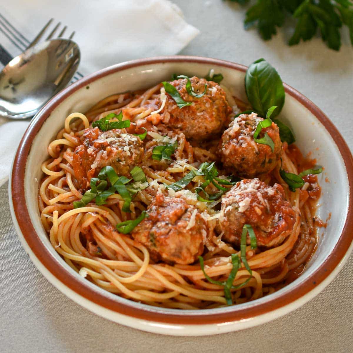 Meatballs with spaghetti and marinara sauce in a bowl.