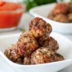 Oven baked meatballs in a small serving dish.