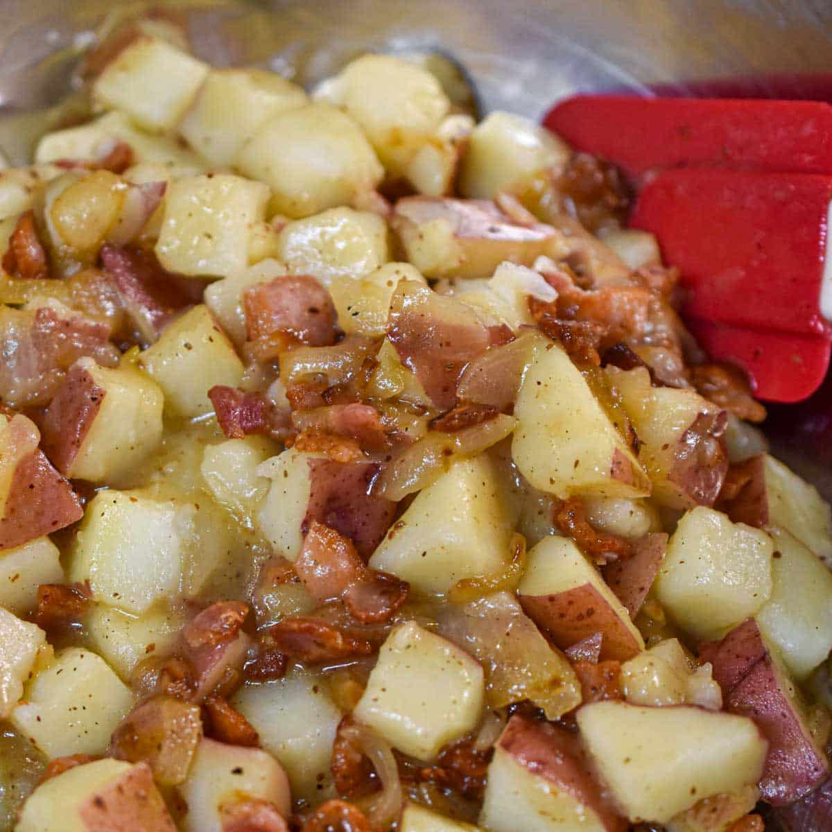 Potato salad in a bowl with spatula.