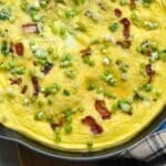 Bacon and cheese frittata that has been baked and is resting before serving.