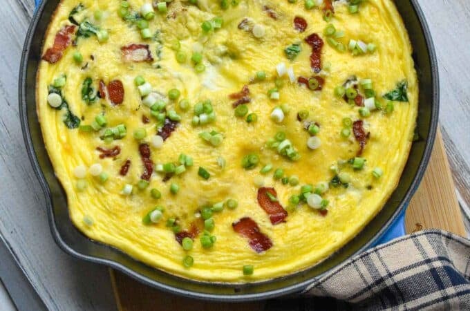 Bacon and cheese frittata that has been baked and is resting before serving.