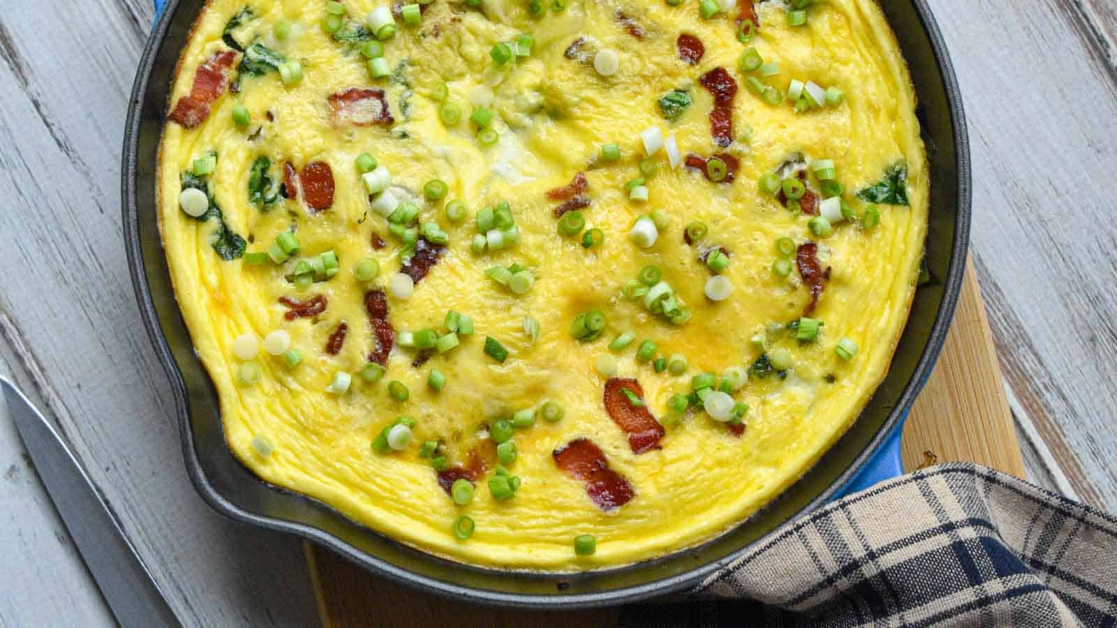 Bacon and cheese frittata that has been baked and is resting before serving.